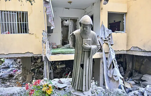 Figura św. Szarbela, maronickiego duchownego, mnicha i pustelnika, przed zniszczonym w izraelskim ataku budynkiem mieszkalnym w zamieszkanym głównie przez chrześcijan mieście Ain Saadeh nieopodal Bejrutu, 6 kwietnia 2026 r.