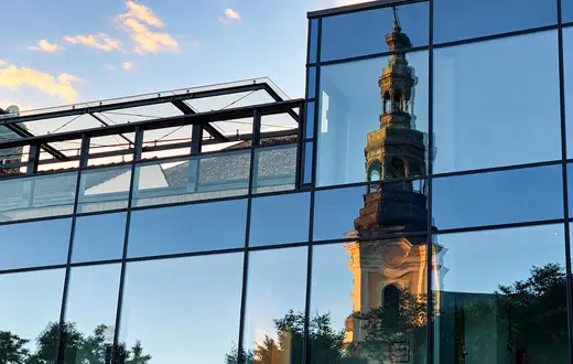 Lustrzane odbicie wieży Kościoła  Franciszkanów w przeszklonej fasadzie nowoczesnego budynku przy Placu Bernardyńskim w Poznaniu | Fot. ks. Wojciech Nowicki
