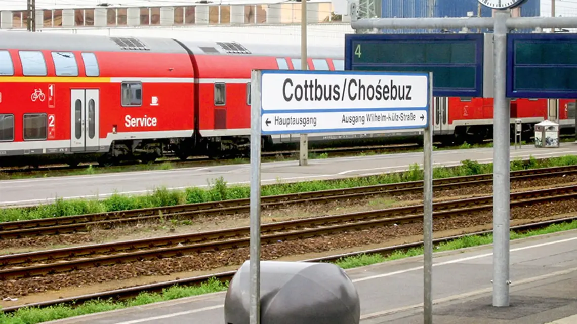 Fot. Mariusz Paździora_Wikipedia_CC BY-SA 4.0. Dwujęzyczna tablica na stacji kolejowej w Chociebużu