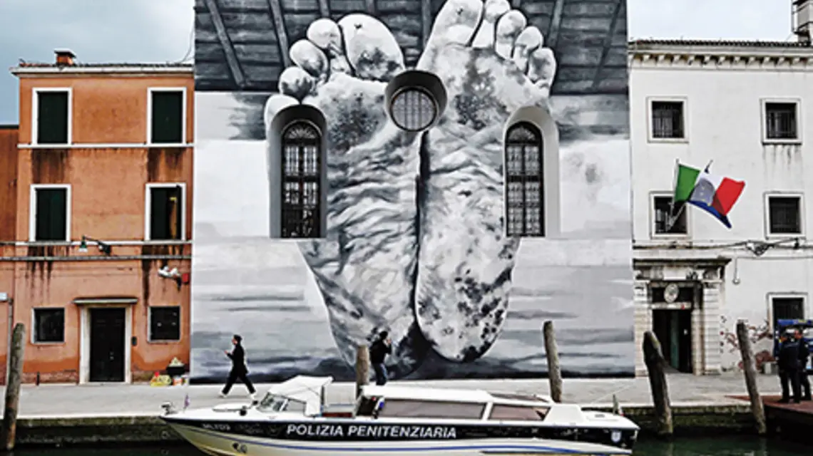 Mural autorstwa Maurizio Cattelana na fasadzie kaplicy więzienia dla kobiet, w którym mieści się pawilon Stolicy Apostolskiej podczas 60. Biennale Sztuki 2024 w Wenecji fot. G. BOUYS / AFP / East News