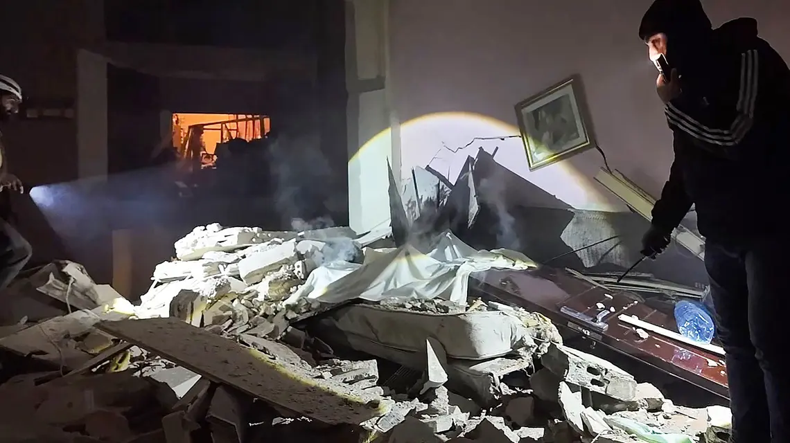 Ratownicy poszukujący w świetle latarek ocalałych mieszkańców w gruzach hotelu, Liban, 4 marca 2026 r. Fot. STR/AFP/East News