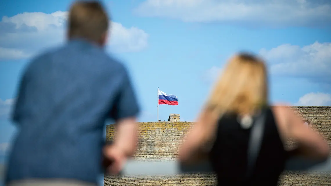 Mieszkańcy Narwy spoglądają na twierdzę w Iwanogrodzie, która znajduje się na drugim brzegu rzeki oddzielającej Estonię od Rosji, 24 lipca 2024 roku fot. Jaap Arriens/NurPhoto/Getty Images