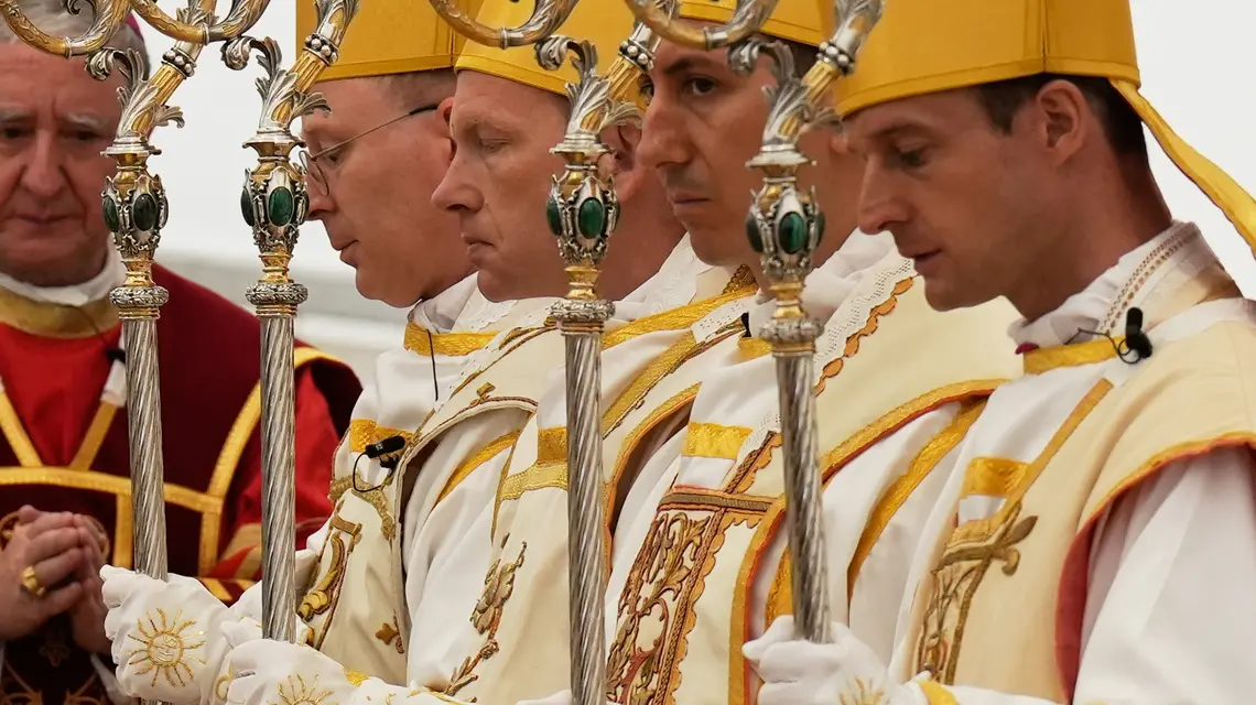 📸Nowo konsekrowani biskupi, od lewej: Pascal Schreiber, Michael Goldade, Michel Poinsinet de Sivry i Marc Hanappier, w mitrach i z pastorałami, modlą się na zakończenie ceremonii konsekracji w namiocie ustawionym przed seminarium Towarzystwa Świętego Piusa X w Écône w Szwajcarii, w środę 1 lipca 2026 roku. Fot. AP Photo/Baz Ratner / EastNews