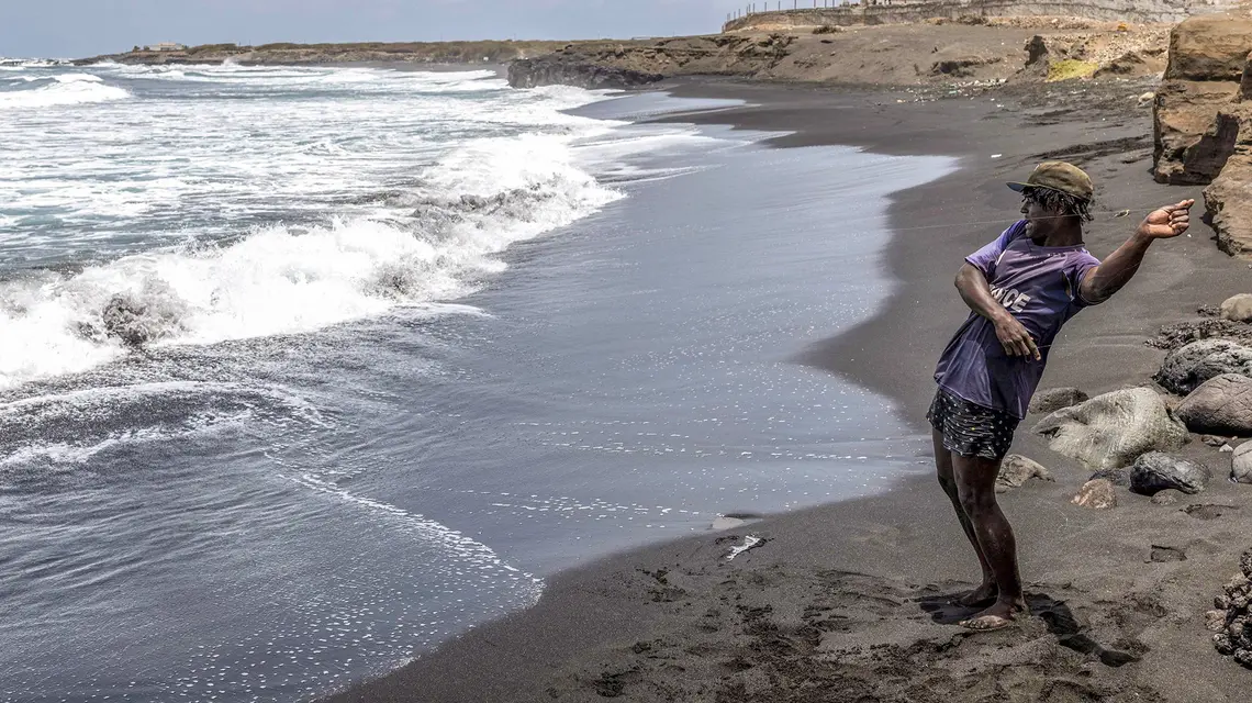 Rybak na plaży na wyspie Santiago, 21 maja 2026 r. Wyspy Zielonego Przylądka słyną z pięknych, piaszczystych plaż, jednak niektóre z nich giną ze względu na nielegalne wydobycie piasku. Z problemem tym mierzą się zwłaszcza uboższe, nieturystyczne regiony wyspy | Fot. Patrick Meinhardt/AFP/East News