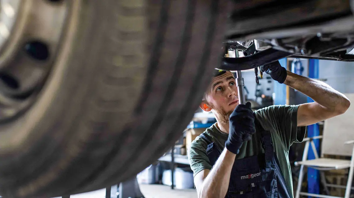 33-letni ukraiński mechanik samochodowy Oleksandr Belyba podczas pracy w warsztacie prowadzonym przez jego przyjaciela z dzieciństwa w Warszawie, 24 czerwca 2025 r. | Fot. WOJTEK RADWANSKI/AFP/East News