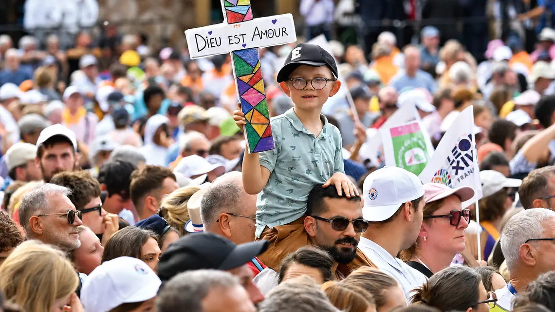 Chłopiec trzymający krzyż z napisem „Bóg jest miłością” przed mszą św. celebrowaną przez papieża Leona XIV w Katedrze św. Szczepana, Francja, Metz, 28 września 2026 r. | Fot. Emma Da Silva/AP/East News