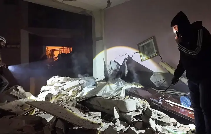 Ratownicy poszukujący w świetle latarek ocalałych mieszkańców w gruzach hotelu, Liban, 4 marca 2026 r. Fot. STR/AFP/East News