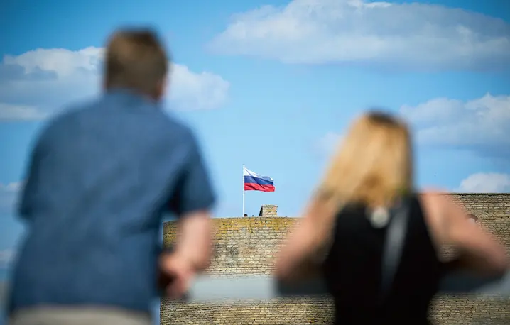Mieszkańcy Narwy spoglądają na twierdzę w Iwanogrodzie, która znajduje się na drugim brzegu rzeki oddzielającej Estonię od Rosji, 24 lipca 2024 roku fot. Jaap Arriens/NurPhoto/Getty Images