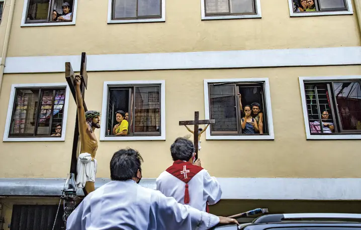 Księża katoliccy z figurą Jezusa na krzyżu, w ramach obchodów Wielkiego Piątku błogosławią mieszkańców poddanych kwarantannie. Filipiny, 10 kwietnia 2020 r. | fot. Ezra Acayan/Getty Images