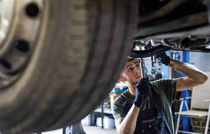 33-letni ukraiński mechanik samochodowy Oleksandr Belyba podczas pracy w warsztacie prowadzonym przez jego przyjaciela z dzieciństwa w Warszawie, 24 czerwca 2025 r. | Fot. WOJTEK RADWANSKI/AFP/East News