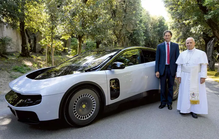  Papież Leon XIV oraz prezes Ferrari John Elkann pozują przy pierwszym w pełni elektrycznym modelu tej marki – „Luce” – podczas prezentacji samochodu papieżowi w jego rezydencji w Castel Gandolfo, 27 maja 2026 r. | fot. AFP photo/Ferrari Press Office/Handout/AFP/East News