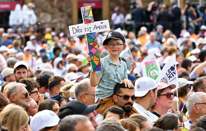 Chłopiec trzymający krzyż z napisem „Bóg jest miłością” przed mszą św. celebrowaną przez papieża Leona XIV w Katedrze św. Szczepana, Francja, Metz, 28 września 2026 r. | Fot. Emma Da Silva/AP/East News