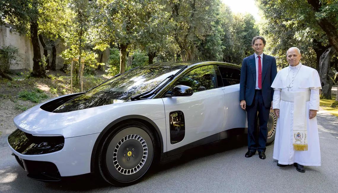  Papież Leon XIV oraz prezes Ferrari John Elkann pozują przy pierwszym w pełni elektrycznym modelu tej marki – „Luce” – podczas prezentacji samochodu papieżowi w jego rezydencji w Castel Gandolfo, 27 maja 2026 r. | fot. AFP photo/Ferrari Press Office/Handout/AFP/East News